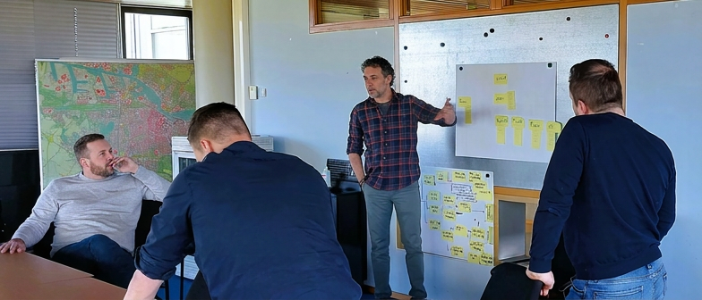 Werksessie: team werkt samen met post-its aan een whiteboard