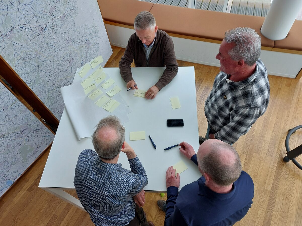Projectteam bespreekt tekeningen tijdens werksessie